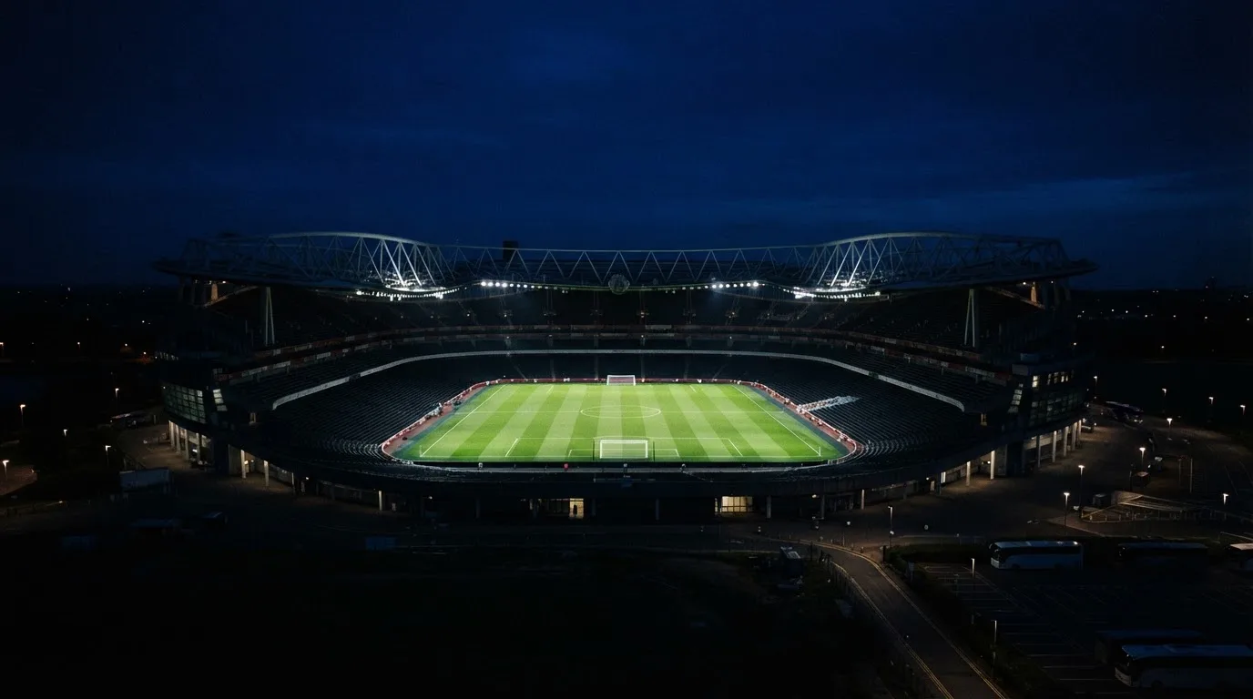 Ein Stadion bei Nacht unter Flutlicht aus der Ferne gesehen, der Rasen ist hell erleuchtet, keine erkennbaren Personen.